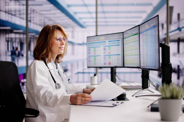 physician reviewing data on multiple monitors in a modern healthcare setting